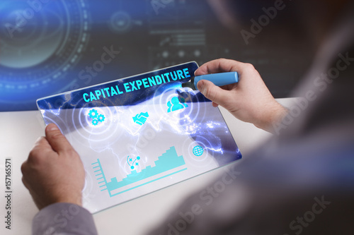 Business, Technology, Internet and network concept. Young businessman working on a virtual screen of the future and sees the inscription: Capital expenditure