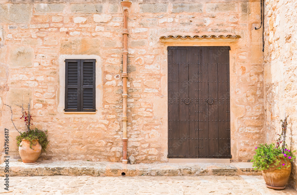 Front Ansicht Haus Mediterran mit Holz Tür Braun Fensterläden und Stein Mauer rustikal