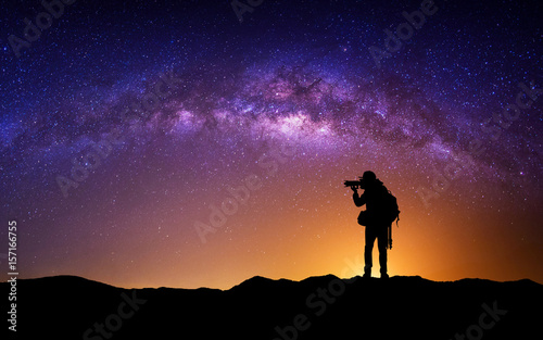Silhouette of photographer with camera and milky way blackground.