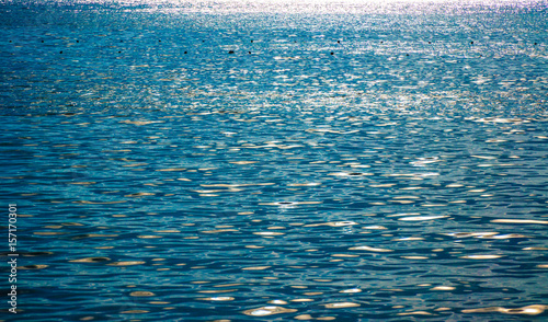 Sky and sea water bokeh. Defocused light reflection on a water surface. Abstract backdrop sea and sun reflecting in the sea. Beautiful background or wallpaper. Blurred sea water.