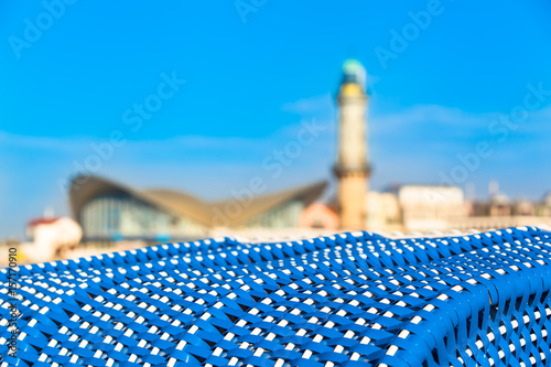 Beach Landmark View / View from blue roofed wicker beach chair to landmarks of Warnemünde (Germany): lighthouse and shell-shaped teapot building at blurred background (copy space)