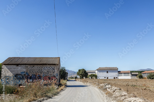 Road in the middle of a small arid population © Óscar
