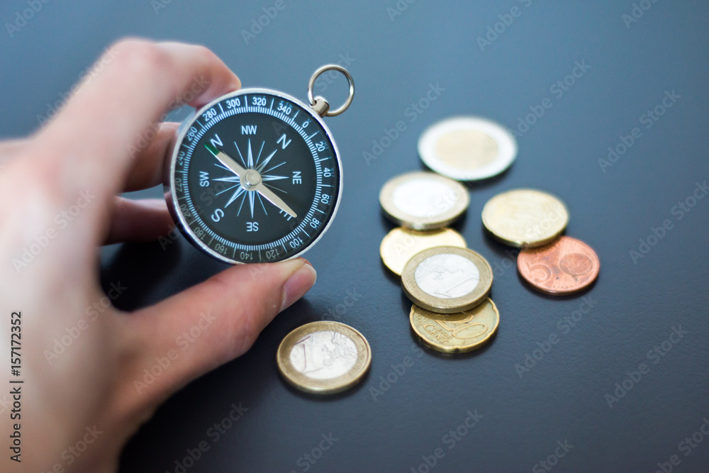 Kompass in Männerhand, Geldstücke