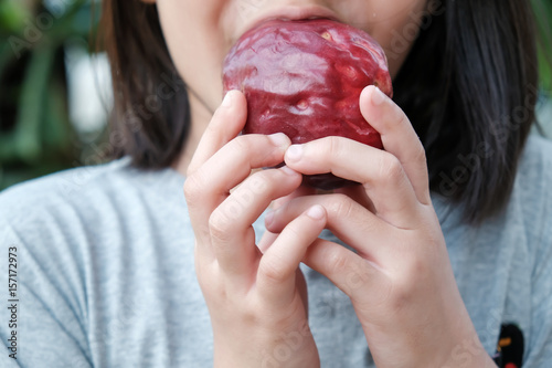 Girl eating Malay Apple (Pomerac) photo