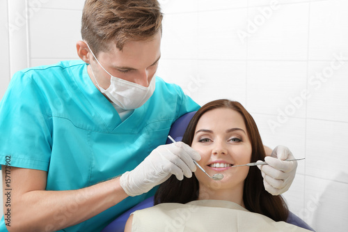 Dentist examining patient t...
