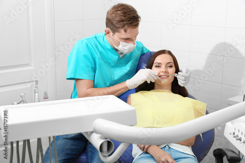 Dentist examining patient t...