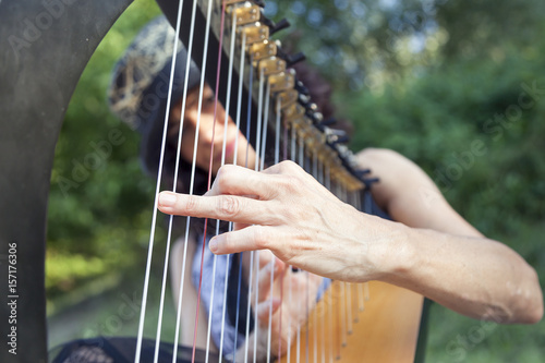 beautiful curly hair woman playing the harp