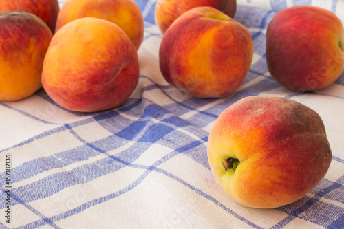 Peaches on a blue and white tablecloth