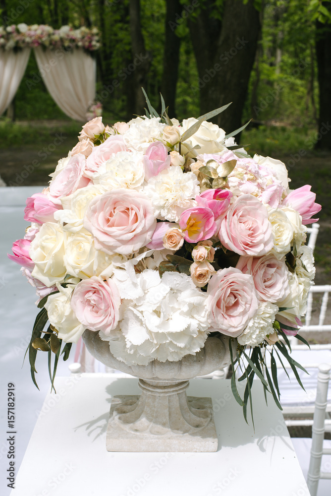 Obraz premium Beautiful wedding bouquet in stone vase, outdoors