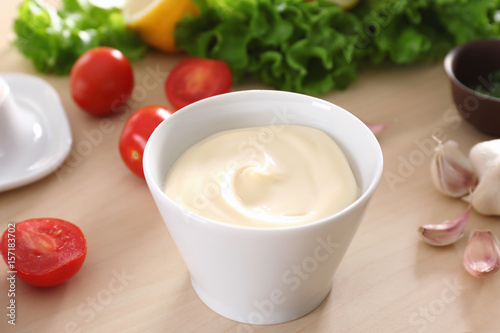 Delicious mayonnaise in bowl on kitchen table, closeup