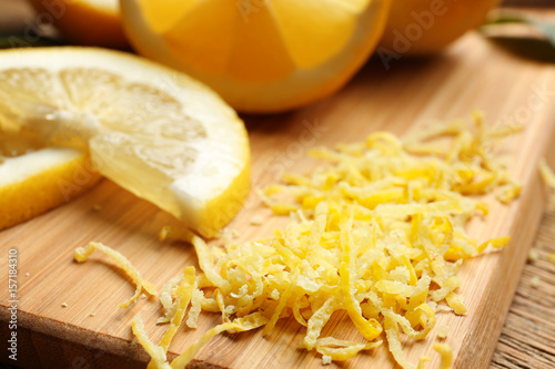Lemon zest and slices on wooden board, closeup