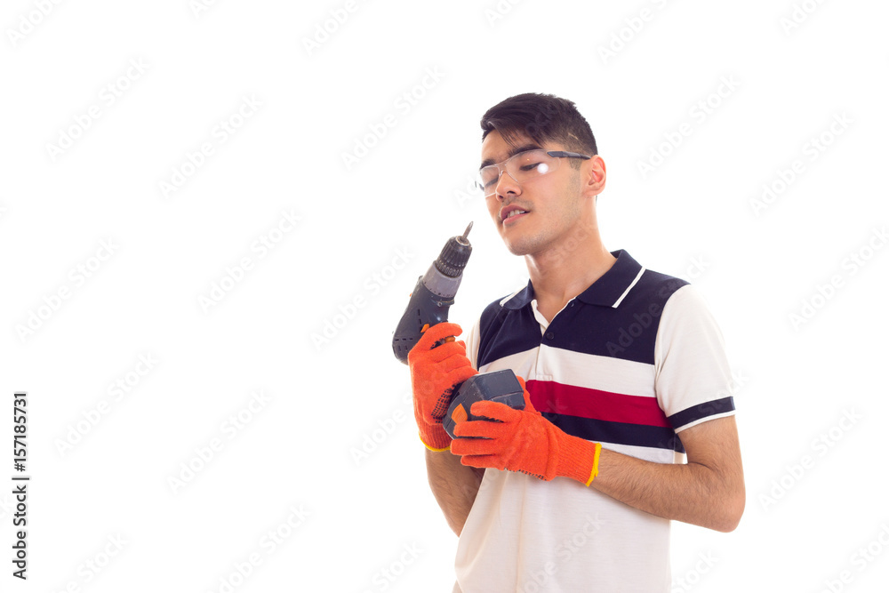 Young man with gloves and glasses holding electric screwdriver Young man with gloves and glasses holding electric screwdriver