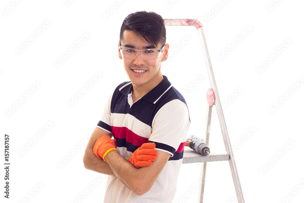 Young man with electric screwdriver and ledder Young man with electric screwdriver and ledder