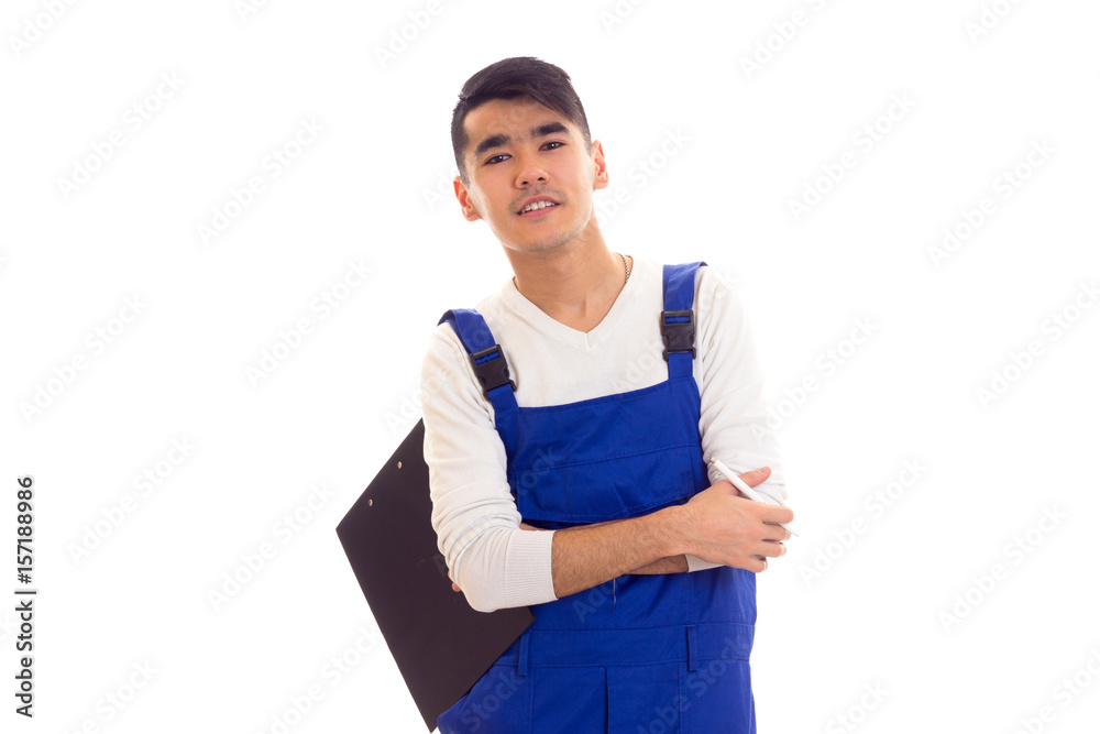 Young man in blue overall holding pen and folder