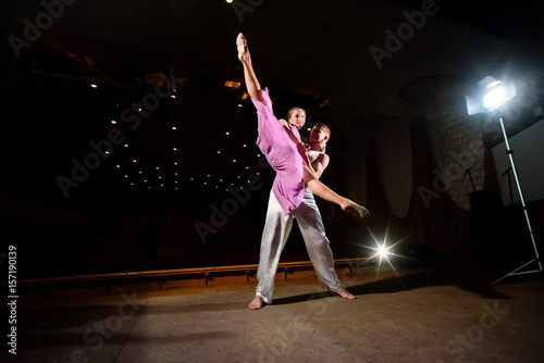 Beautiful couple dancing on the dark stage.