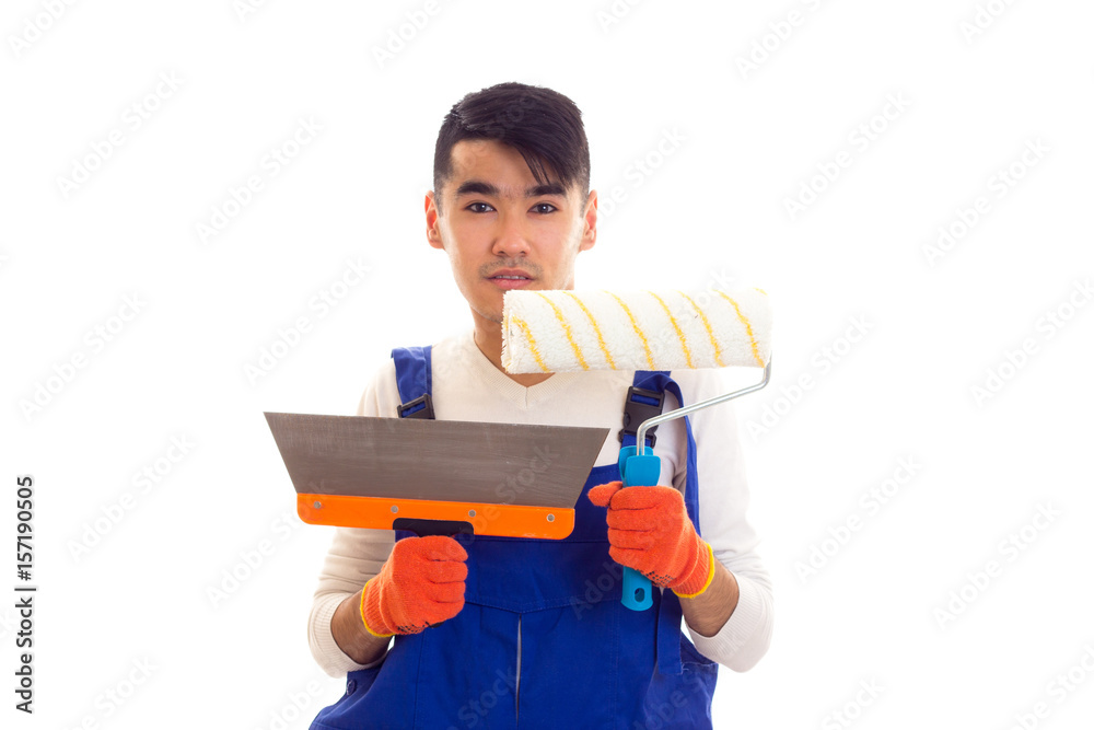 Man in blue overall with gloves holding spatula and roll Man in blue overall with gloves holding spatula and roll