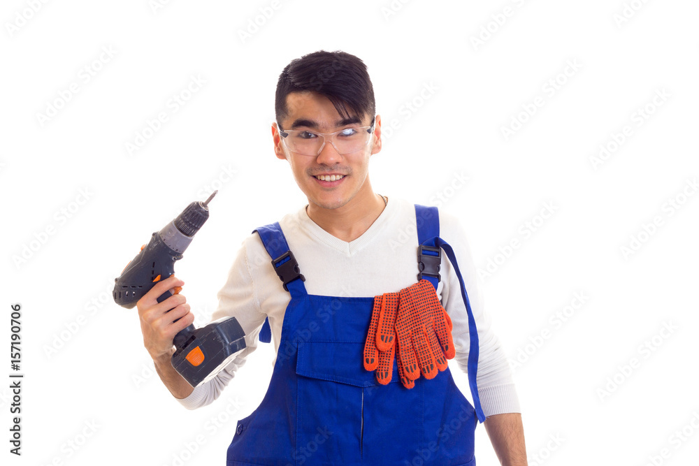 Man in overall with gloves and glasses holding electric screwdriver Man in overall with gloves and glasses holding electric screwdriver