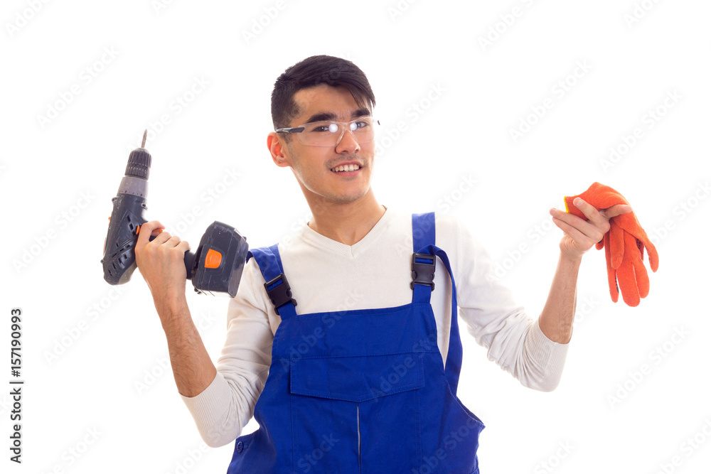 Man in overall with gloves and glasses holding electric screwdriver Man in overall with gloves and glasses holding electric screwdriver