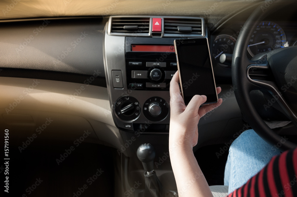Woman using a smartphone while driving a car between driving because addict social media Woman using a smartphone while driving a car between driving because addict social media