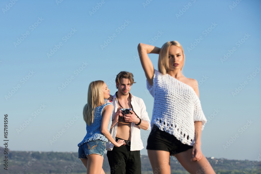 man with camera in hand taking photo of women, girls man with camera in hand taking photo of women, girls