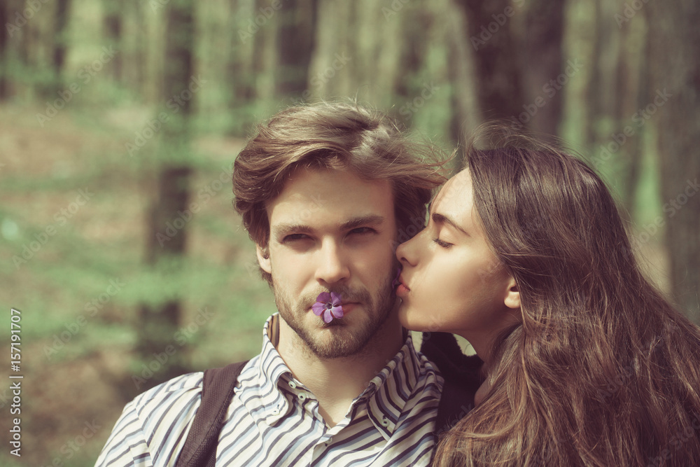 boyfriend and girlfriend with blue flowers in mouths boyfriend and girlfriend with blue flowers in mouths