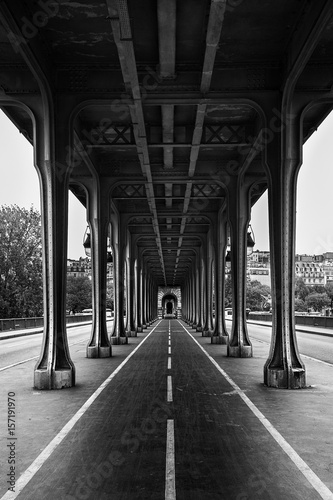 Metal columns and abutments of '' Bir Hakeim '' bridge. People walks and make jogging under the bridge in Paris.The bridge is one of the most famous and historic landmark