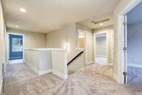 Second floor landing with creamy walls and beige carpet floor