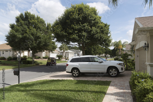 Luxury car parked on the driveway of a house in a Florida residential area reserved for mid aged people, USA 2017
