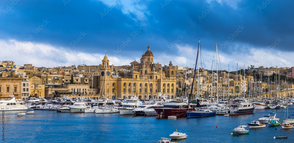 Senglea, Malta - Panoramic vew of yachts and sailing boats mooring at Senglea marina in Grand Canal of Malta on a bright sunny summer day woth blue sky and clouds