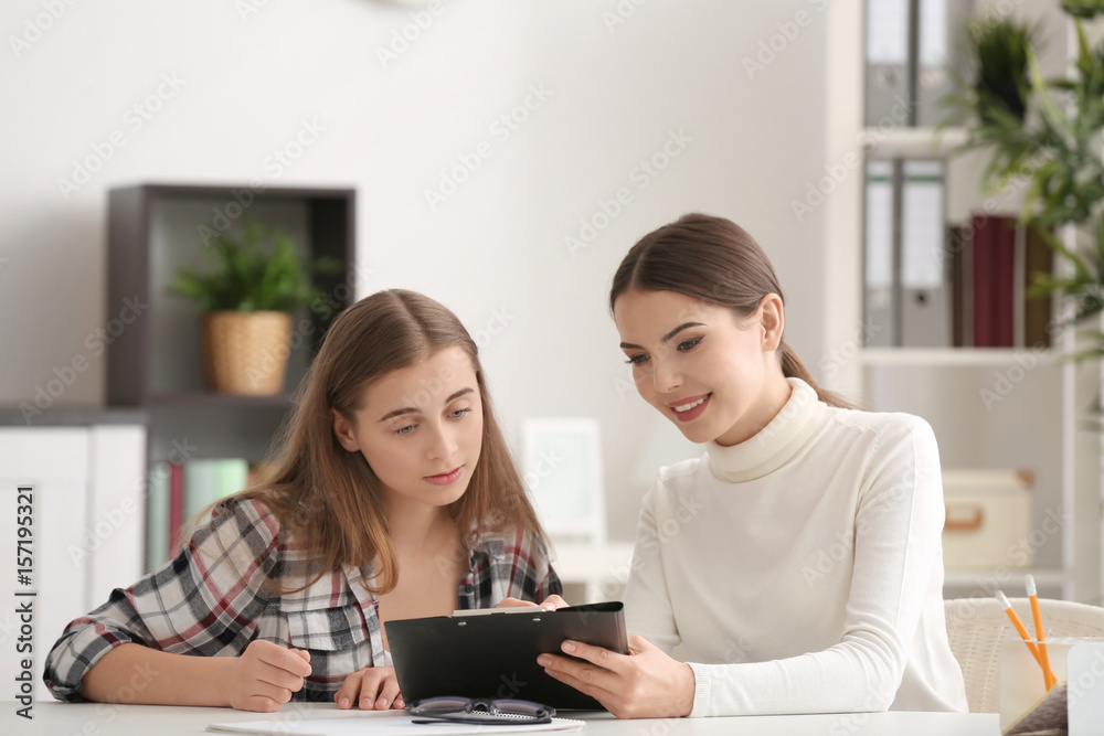 Young female psychologist working with teenager girl in office Young female psychologist working with teenager girl in office