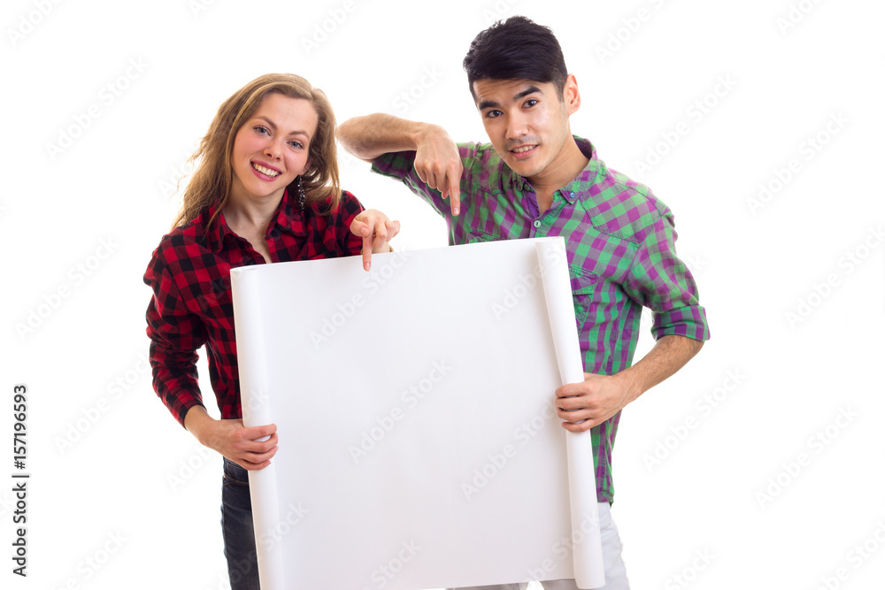 Young couple in plaid shirts holding placard Young couple in plaid shirts holding placard