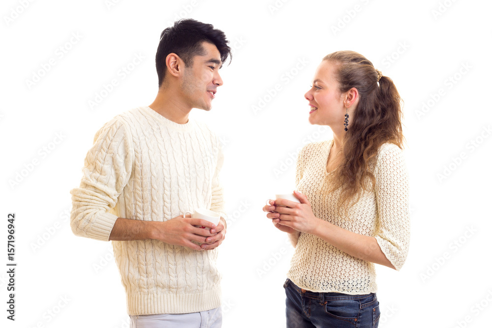 Young couple holding cups and talking Young couple holding cups and talking