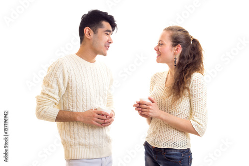 Young couple holding cups and talking
