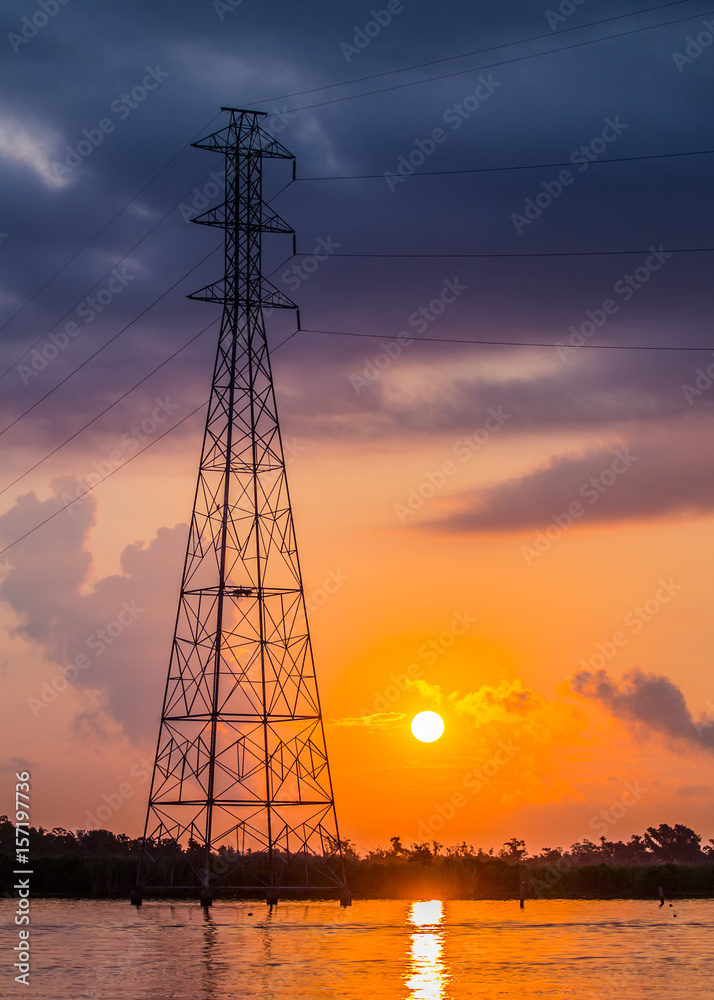 Electric Power Tower In Marsh At Sunrise