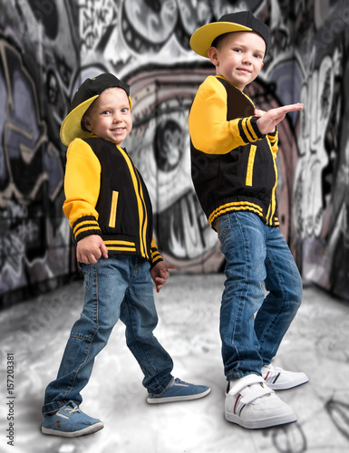 Two brothers  in the style of hip hop.Fashionable team.Graffiti on the walls. © Denis