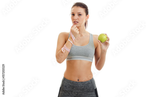 beautiful fitness girl looks ahead and holds in his hand a Apple