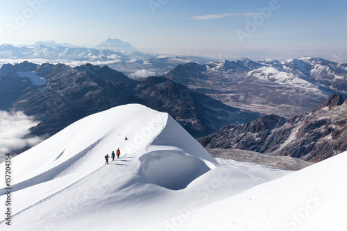 Mountaineers walking climbing snow trail mountains ridge, Bolivia.