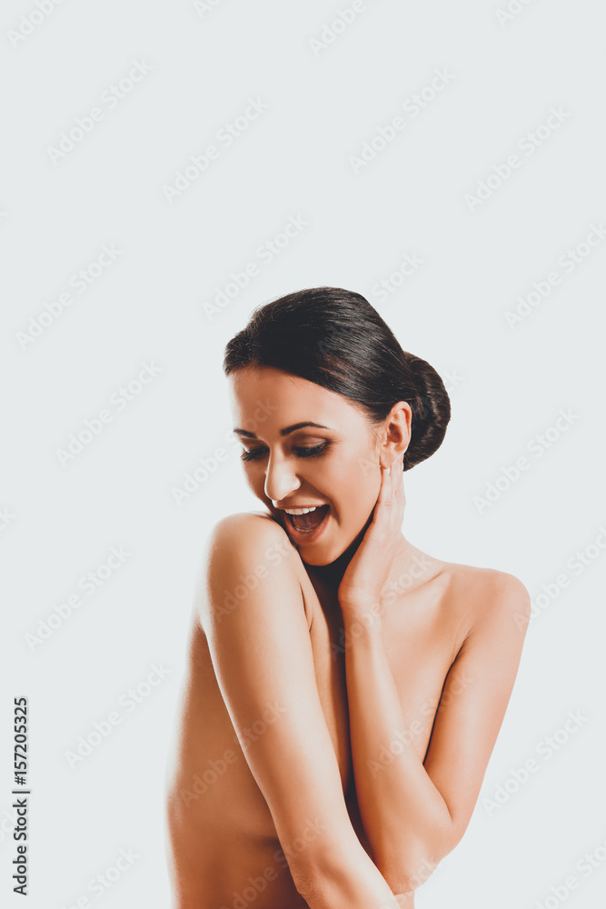 Topless woman sitting on desk, touching her neck Topless woman sitting on desk, touching her neck