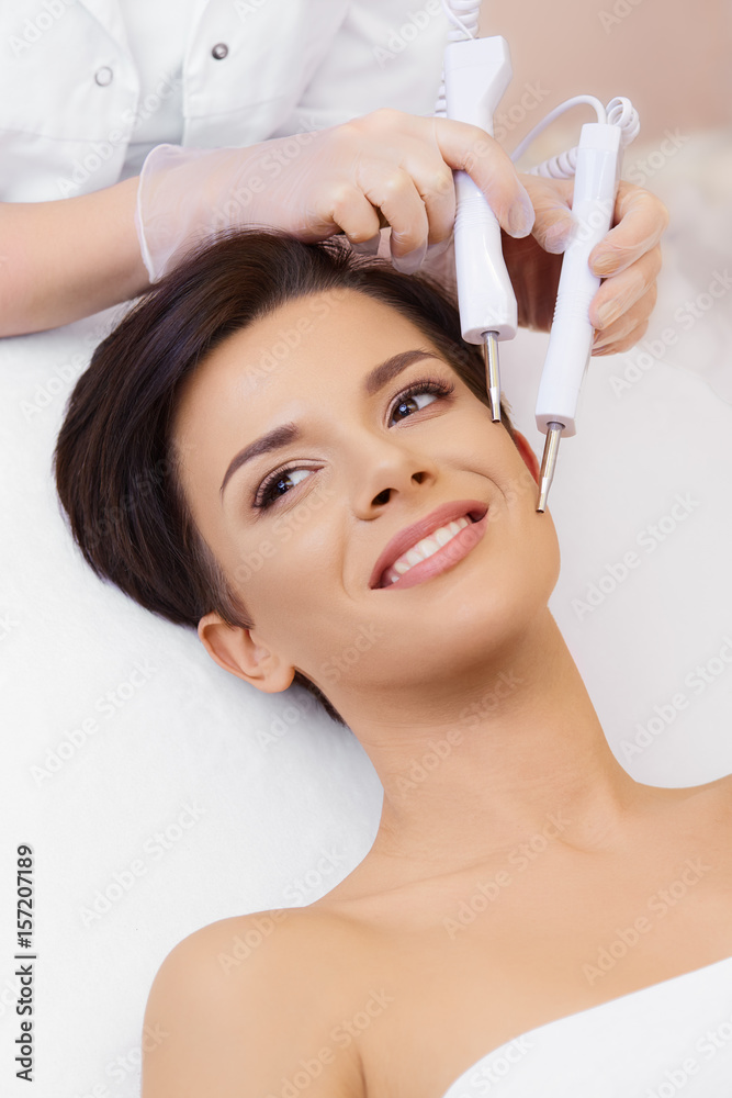 Cosmetology. Spa clinic. Beautiful woman at facial treatment procedure. Young healthy skin. Facial mask. Skin rejuvenation.