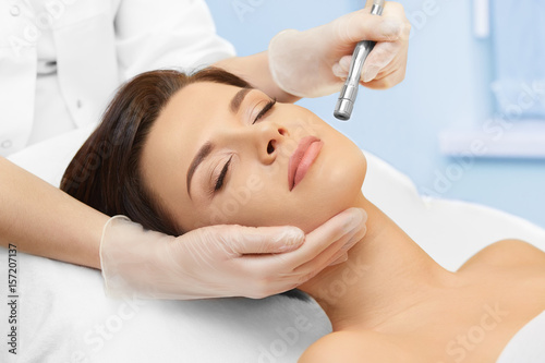 Cosmetology. Spa clinic. Beautiful woman at facial treatment procedure. Young healthy skin. Facial mask. Skin rejuvenation.