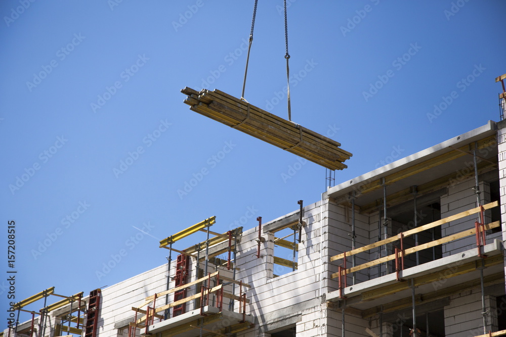 Naklejka premium Industrial crane operating and lifting building materials