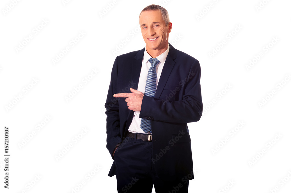 Mature businessman pointing to the left Mature businessman pointing to the left