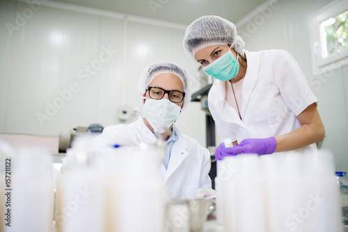 Doctor and nurse doing chemical analysis in a cosmetic production laboratory.