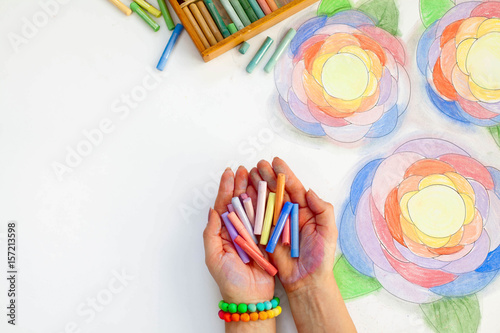 Flowers drawn art with pastels. Pencil, markers and hands of the artist on a white background. photo