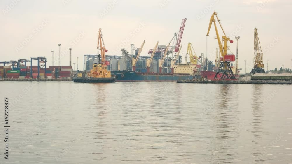 Tugboat and port. Cranes at the harbor. Ship maintenance and repair. Tugboat and port. Cranes at the harbor. Ship maintenance and repair.