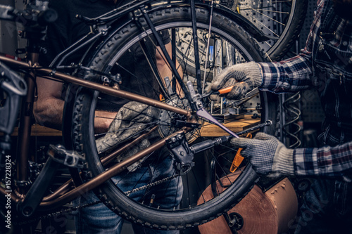 Mechanic fixing rear derailleur from a bicycle.