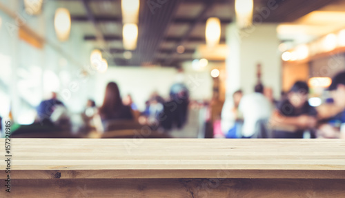 Wood table top with blur of people in coffee shop or  cafe restaurant  background.For montage product display or key visual layout