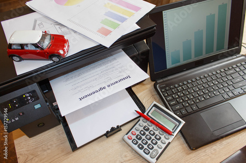 Homeowner and car Insurance form with Laptop, Printer, pen, calculator on the table