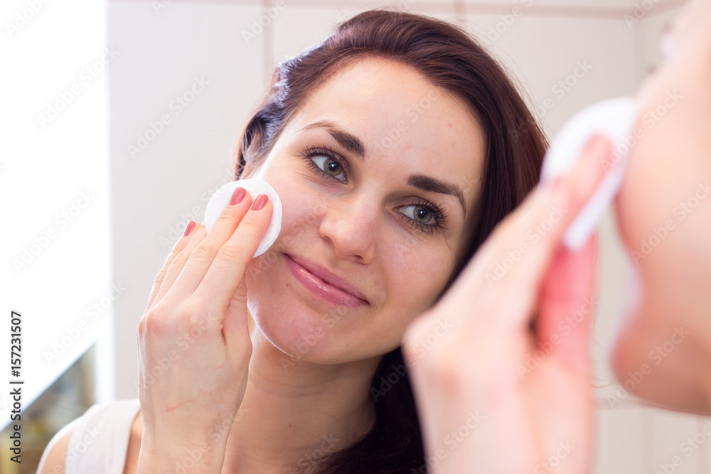 Young woman removing makeup in bathroom Young woman removing makeup in bathroom
