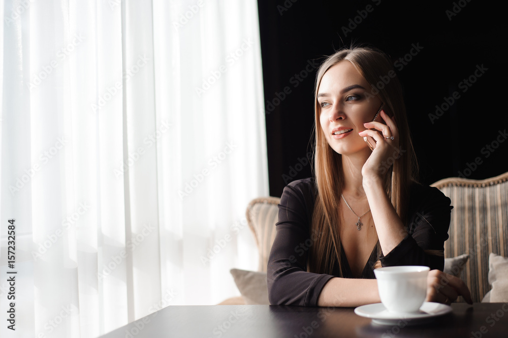 attractive female with cute smile having talking conversation with mobile phone while rest in cafe attractive female with cute smile having talking conversation with mobile phone while rest in cafe